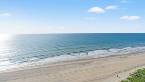 Una playa con cielo despejado y mar tranquilo.