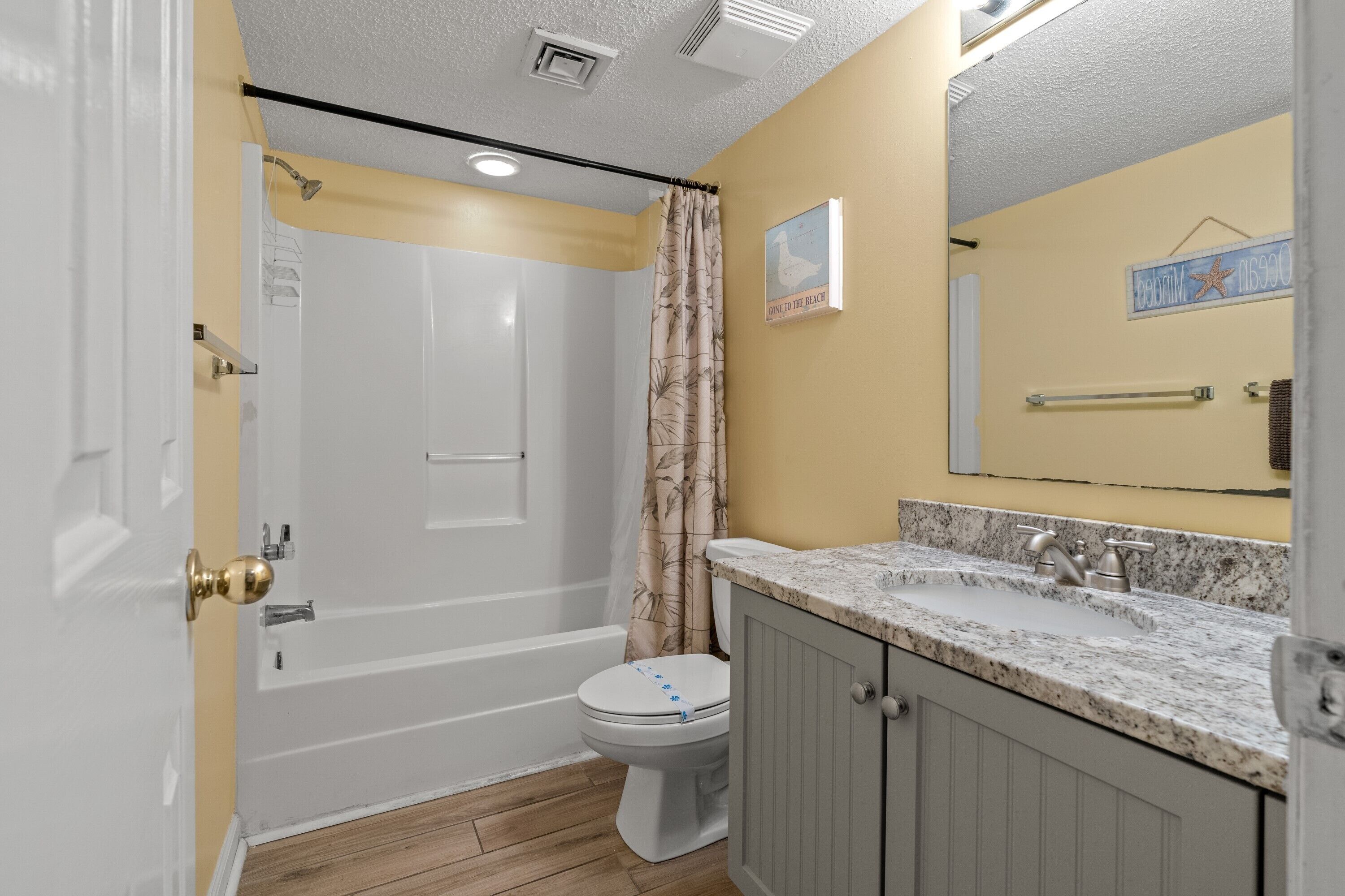 Une salle de bain avec une baignoire, des toilettes et un meuble-lavabo avec un évier.