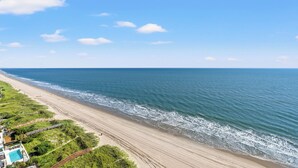 A beach with a clear view of the ocean, a sandy shoreline, and a pool area with a fence. - Ocean Bay Club 1605-4BR/3BA Oceanfront-Ocean Drive (North Myrtle Beach)