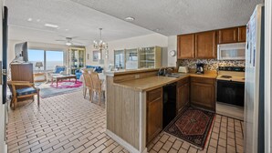 A spacious kitchen with wooden cabinets, a built-in island, and a large window.