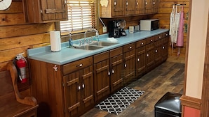 A kitchen with wooden cabinets, a large island, and a hanging sign that reads "GASUN FOOD".