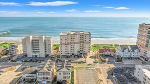 Un complexe hôtelier situé sur la côte, composé de plusieurs bâtiments, dont une tour imposante sur laquelle on peut lire le nom « Kendall ». On aperçoit également des espaces de stationnement et une plage à l’arrière-plan.