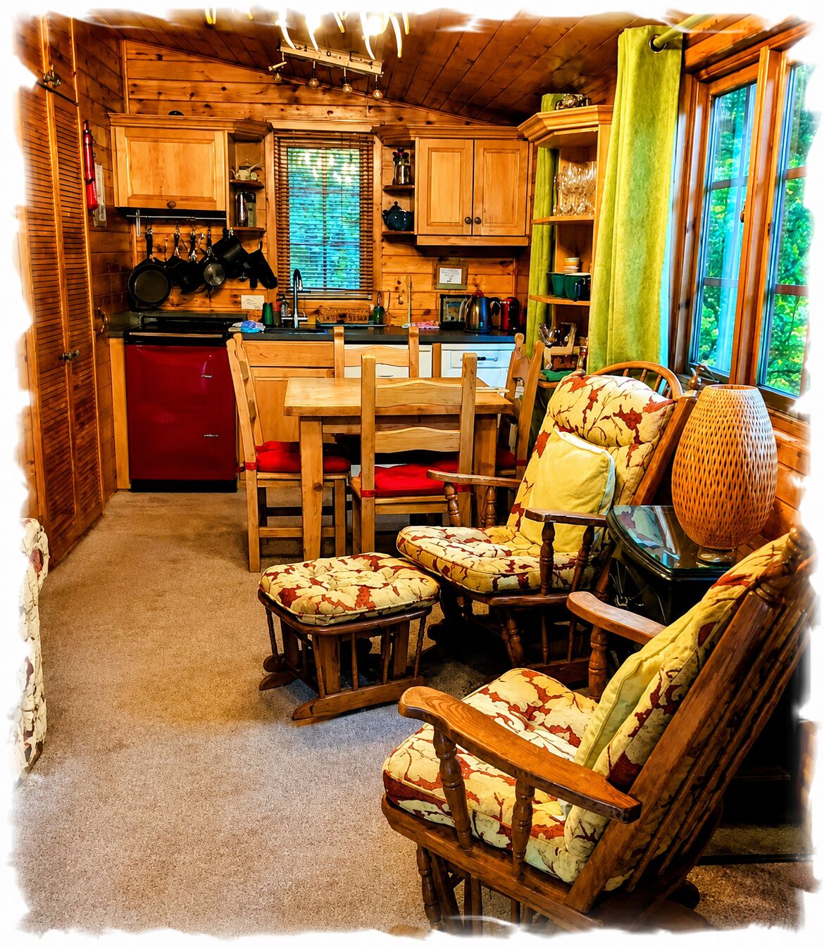 A cozy cabin interior with a dining area, wooden furniture, and a kitchen.