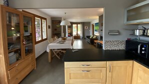 A modern kitchen with wooden cabinets, a black countertop, and a built-in oven. - Beautiful villa with sea view, 2.5km from the beach, in the heart of nature   (Bormes-les-Mimosas)