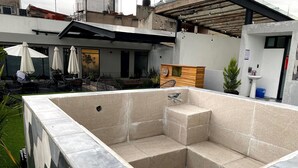 Un espace piscine extérieur moderne, agrémenté d’un mur en pierre et d’une terrasse en bois.