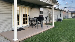 A house with a covered porch, a small table with chairs, and a door with glass panels. - Matthew Estates Ranch (Dandridge)