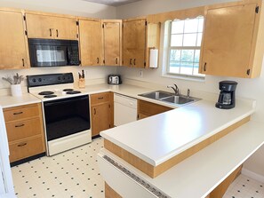 Enjoy cooking in this well-equipped kitchen with a central island, stovetop, and double sink.