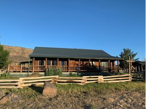 Eine Lodge mit grüner Dachbegrünung, Holzfassade und einer Veranda mit Zäun.