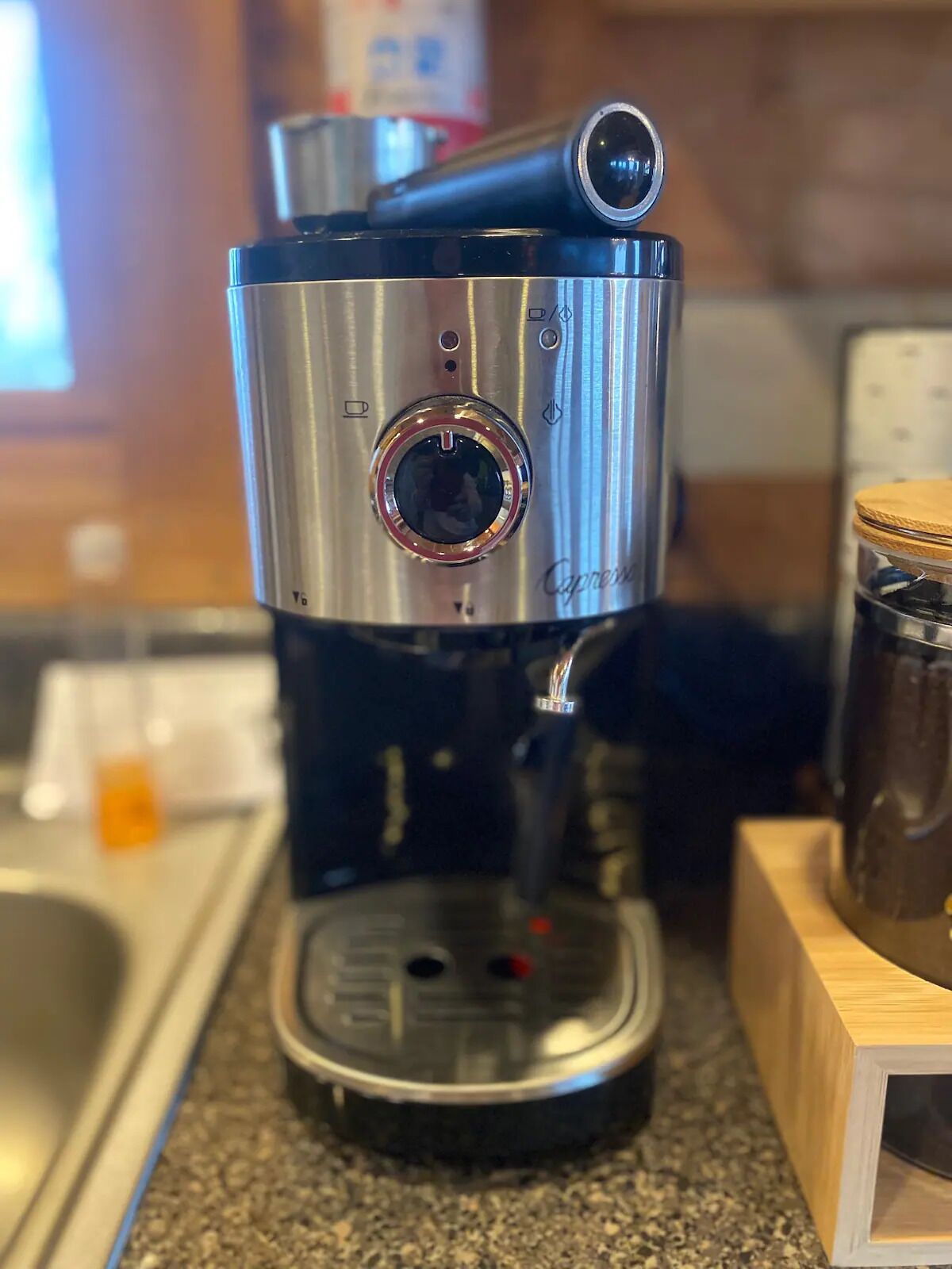 Una cafetera con pantalla digital y un recipiente para recoger las gotas sobre una encimera de cocina.