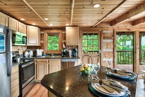 Eine geräumige Küche mit Holzschränken, Edelstahlgeräten und einer Arbeitsplatte aus Granit.