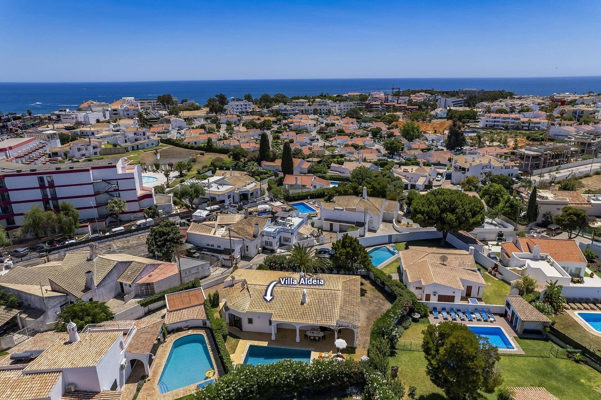 Villa Aldeia, a residential area with multiple houses, a swimming pool, and a view of the sea.