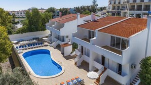 Um edifício moderno de dois andares com piscina e área de estar ao ar livre.