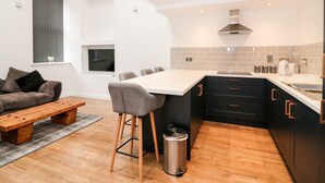 Een moderne keuken met een eethoek, een inbouwoven en een groot raam.