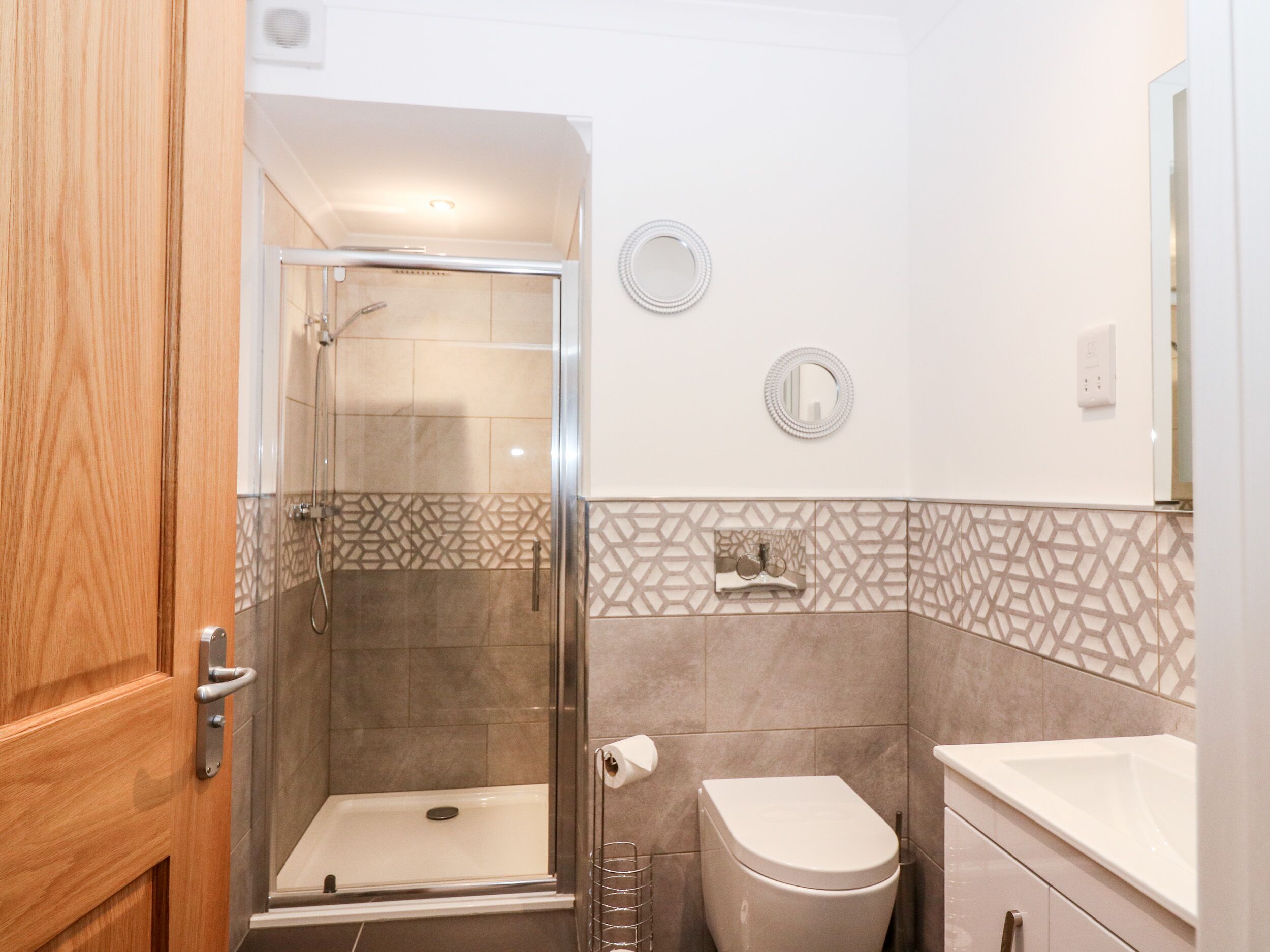 A bathroom with a shower, toilet, and sink.