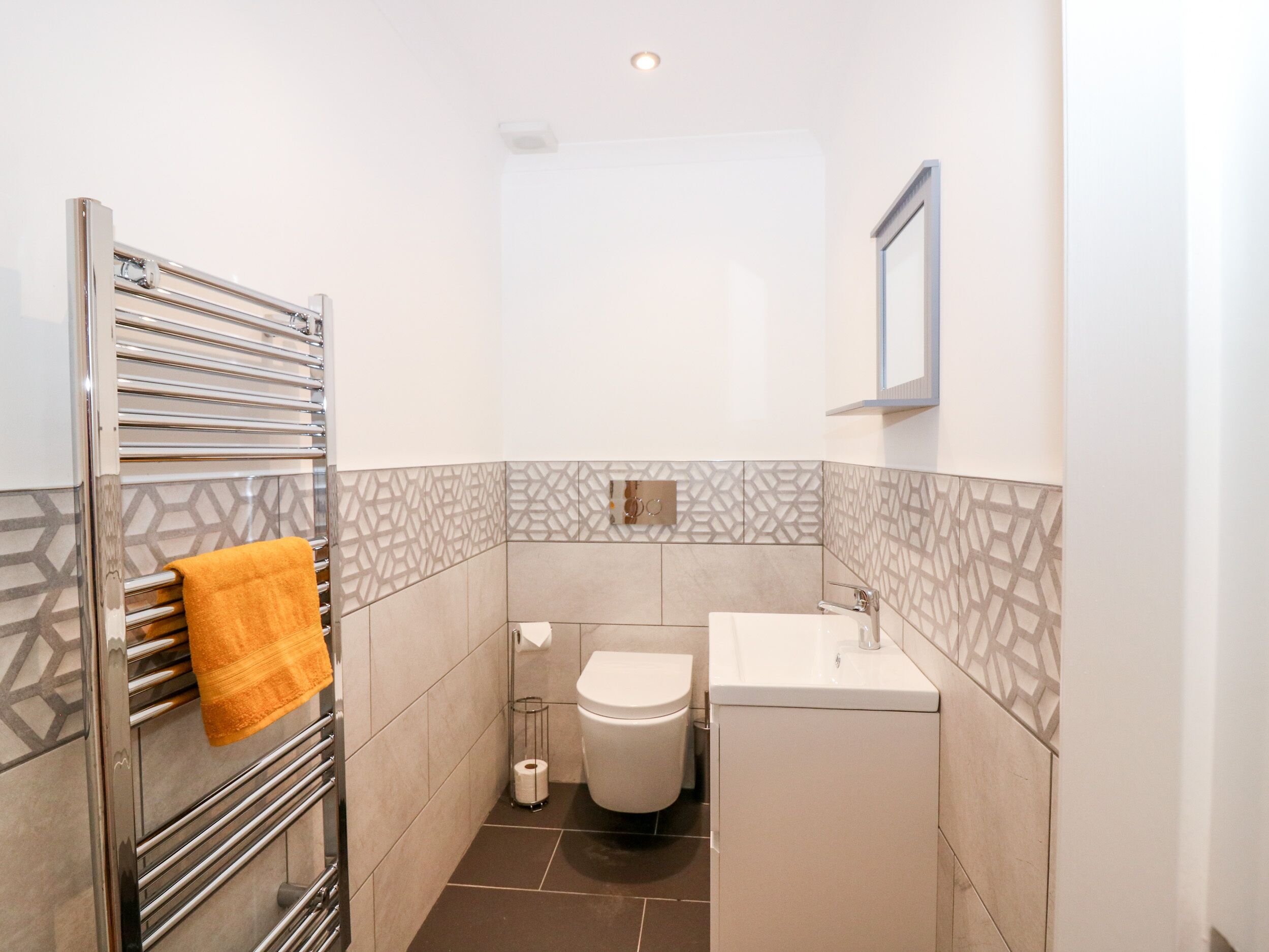 Une petite salle de bain avec des toilettes, un lavabo et un porte-serviettes.