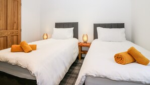 A hotel room with two beds, wooden wardrobe, and bedside lamps. - The Keepers Cottage at The Institute Executive Apartments (Keith)
