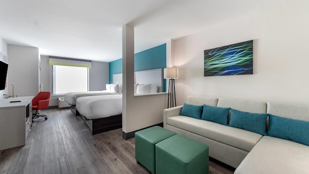 A modern hotel room with a bed, a sofa, a desk, and a chair. - Comfort Suites Colorado Springs East -Medical Center Area (Colorado Springs)