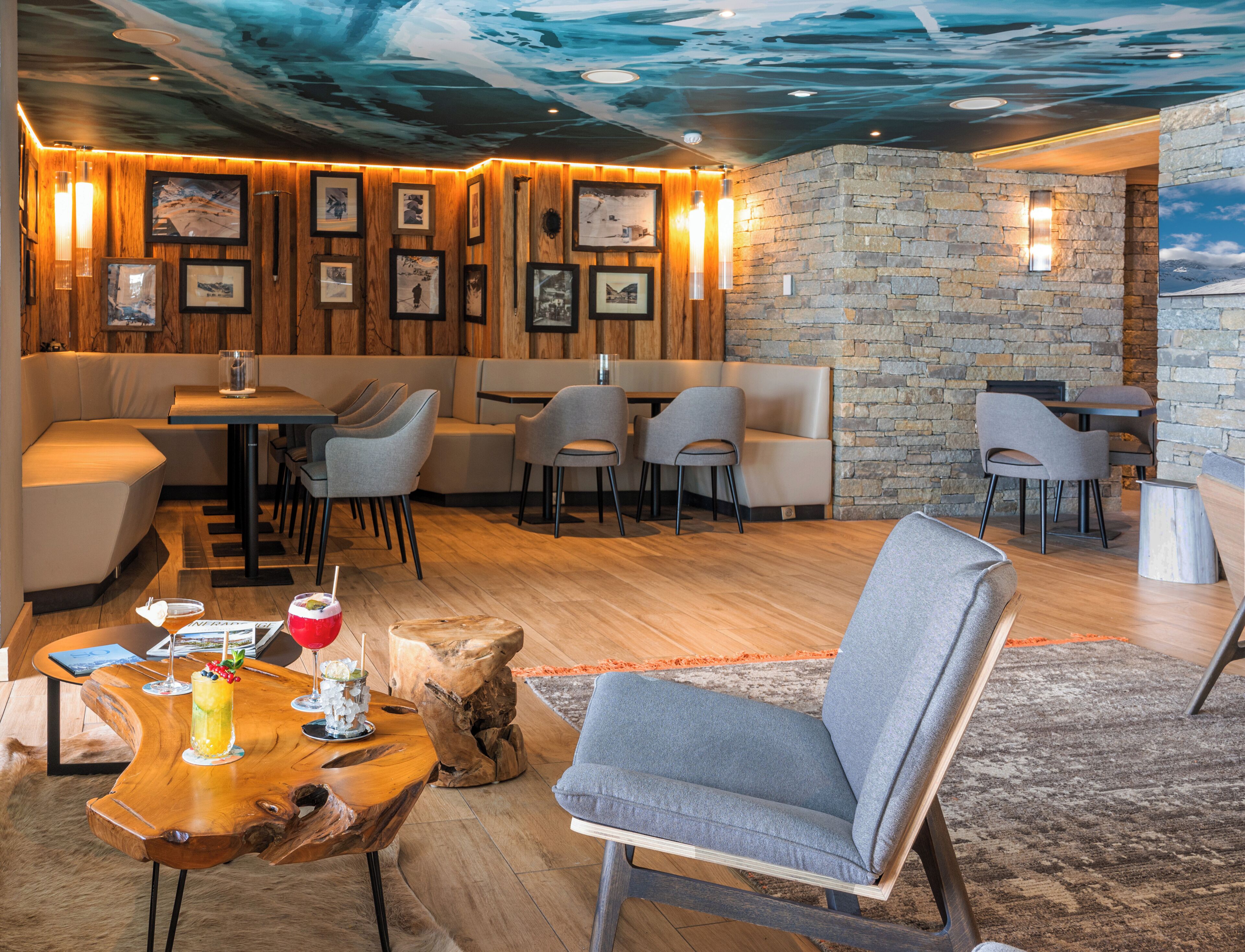 Un restaurant moderne aux murs en bois, agrémenté d’éléments en pierre, et offrant différents types de sièges.