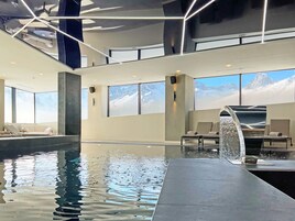 Una piscina techada, sillones reclinables de piscina