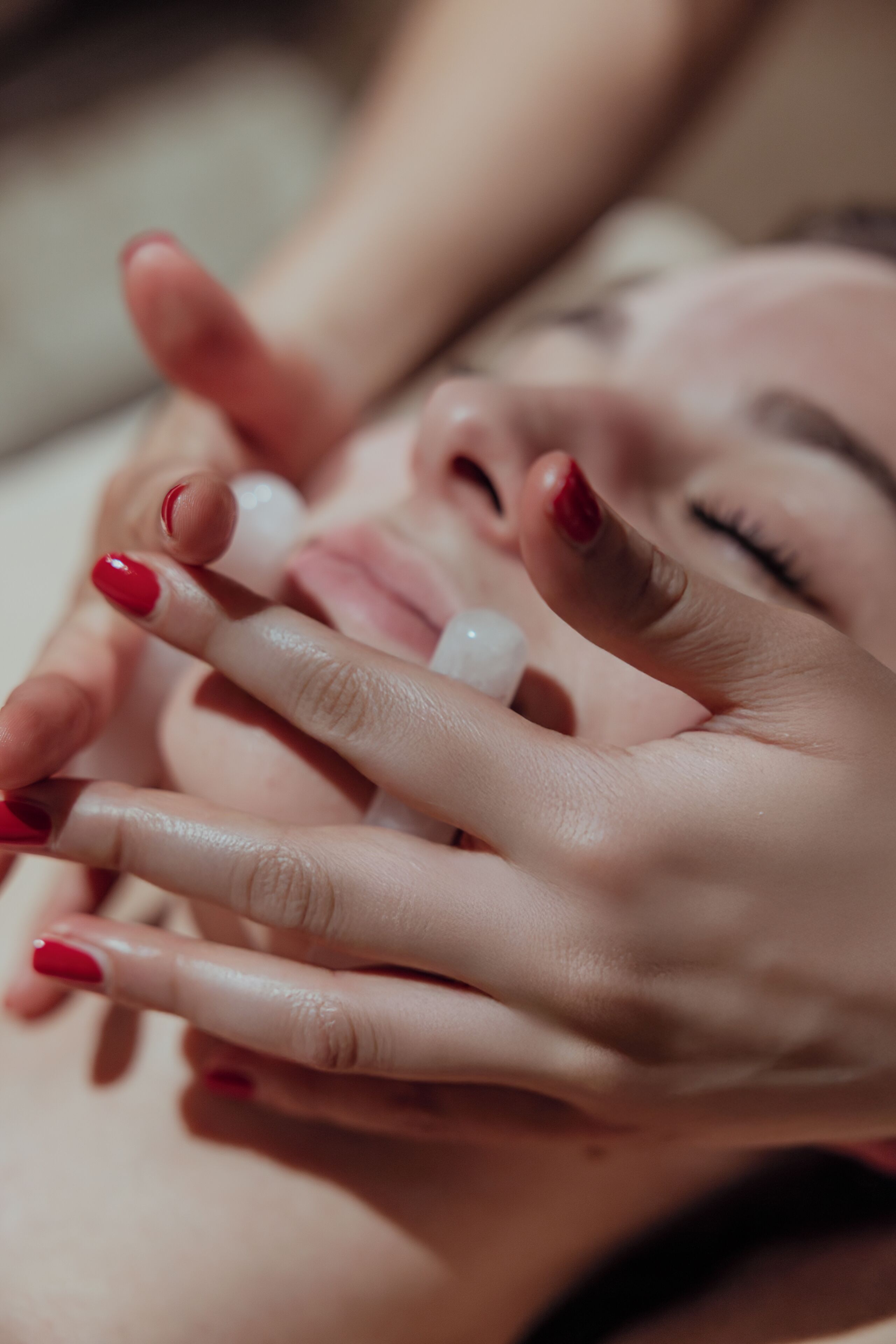 A close-up of hands with red nail polish.