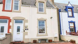 A row of terraced houses with distinct architectural styles and colors. - Harbour View (Buckie)