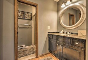 Enjoy a refreshing shower in the walk-in shower with a glass door, paired with a spacious vanity and large mirror.