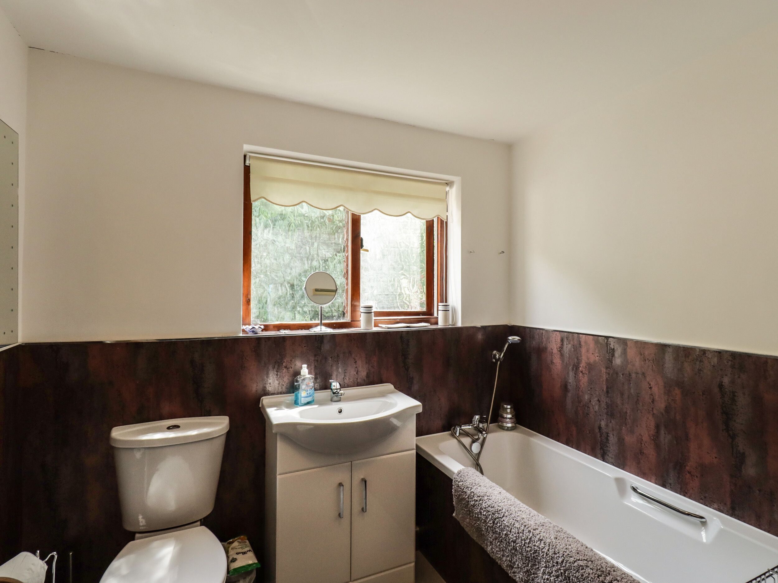 A bathroom with a toilet, sink, and bathtub.