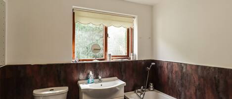A bathroom with a toilet, sink, and bathtub.