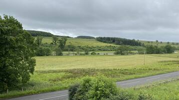 A rural landscape with a road curving through fields and hills.