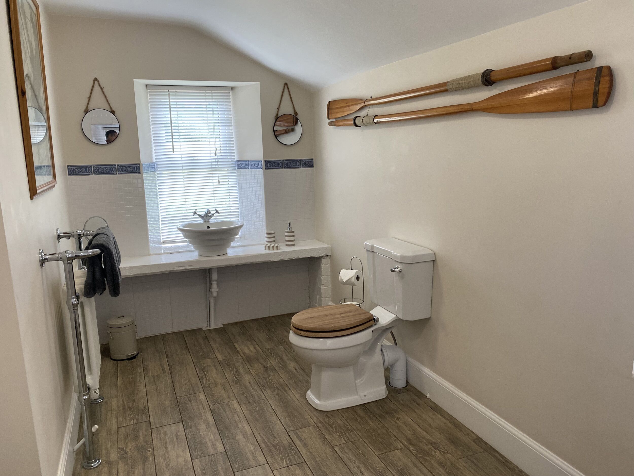 A compact bathroom with a toilet, sink, and window.