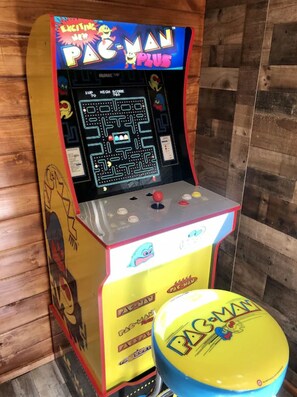 Une borne d’arcade Pac-Man aux couleurs jaune et bleu, proposant un jeu de labyrinthe et un affichage du score.