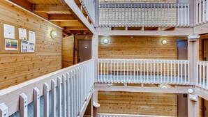 Une cabane en bois à plusieurs niveaux, dotée de balcons et d’un intérieur également en bois.