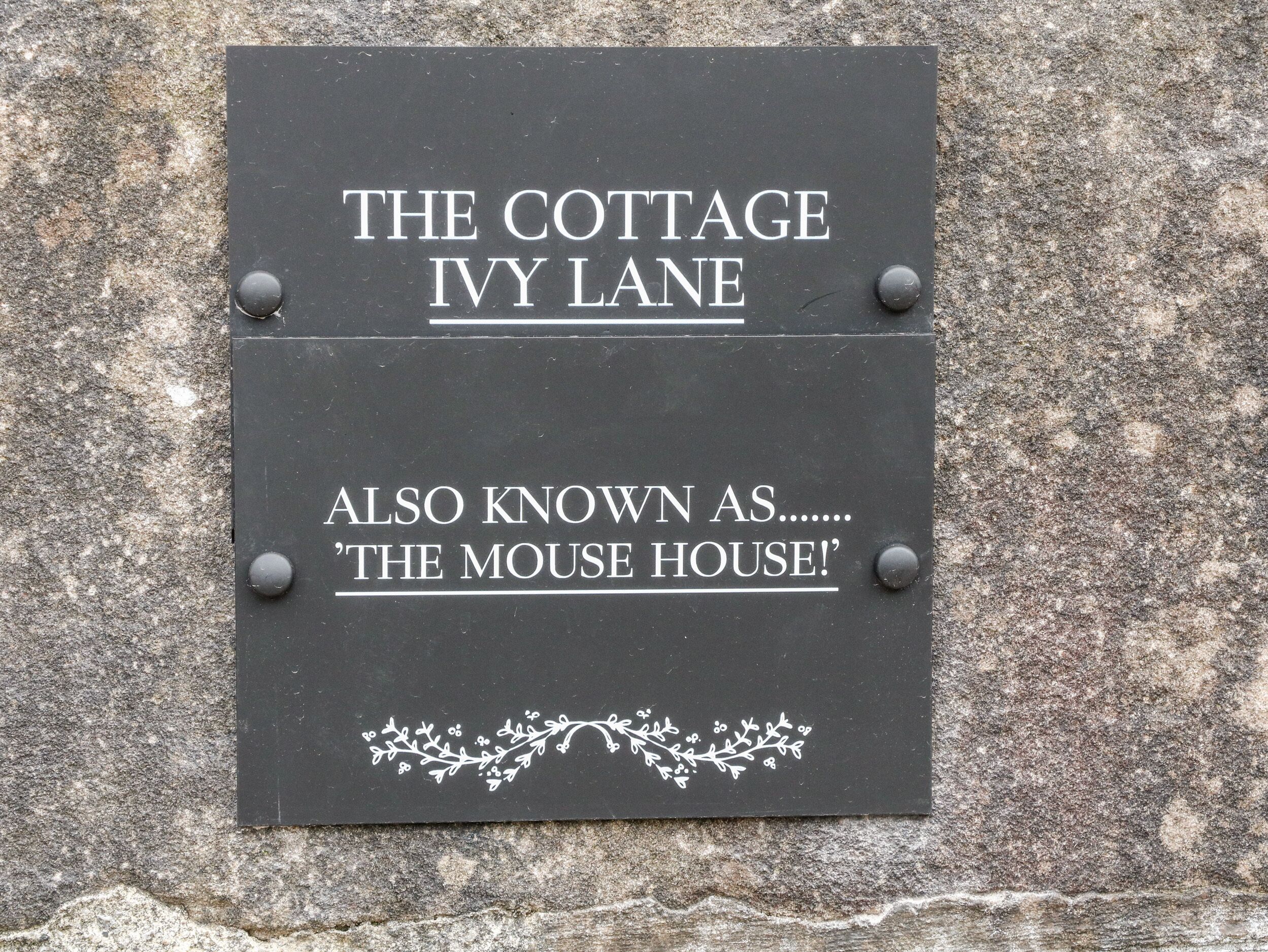 Un cartel indica 'The Cottage Ivy Lane', también conocido como 'The Mouse House'.