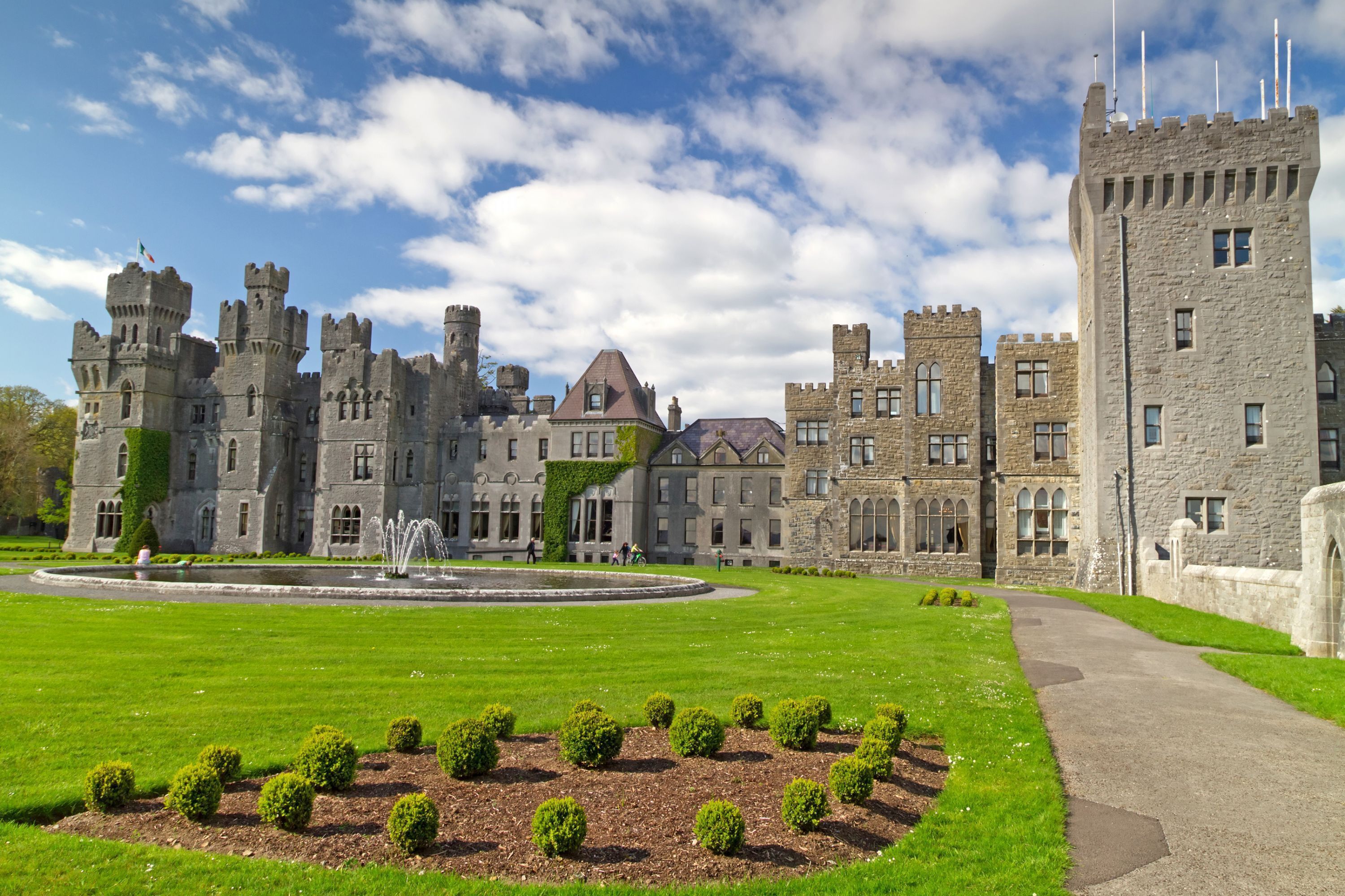 A large castle-like building with multiple towers and a central courtyard with a fountain.