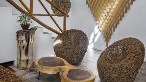 A room with a thatched roof, woven furniture, and a staircase with wooden beams. - Verandah Studios (Playa del Carmen)