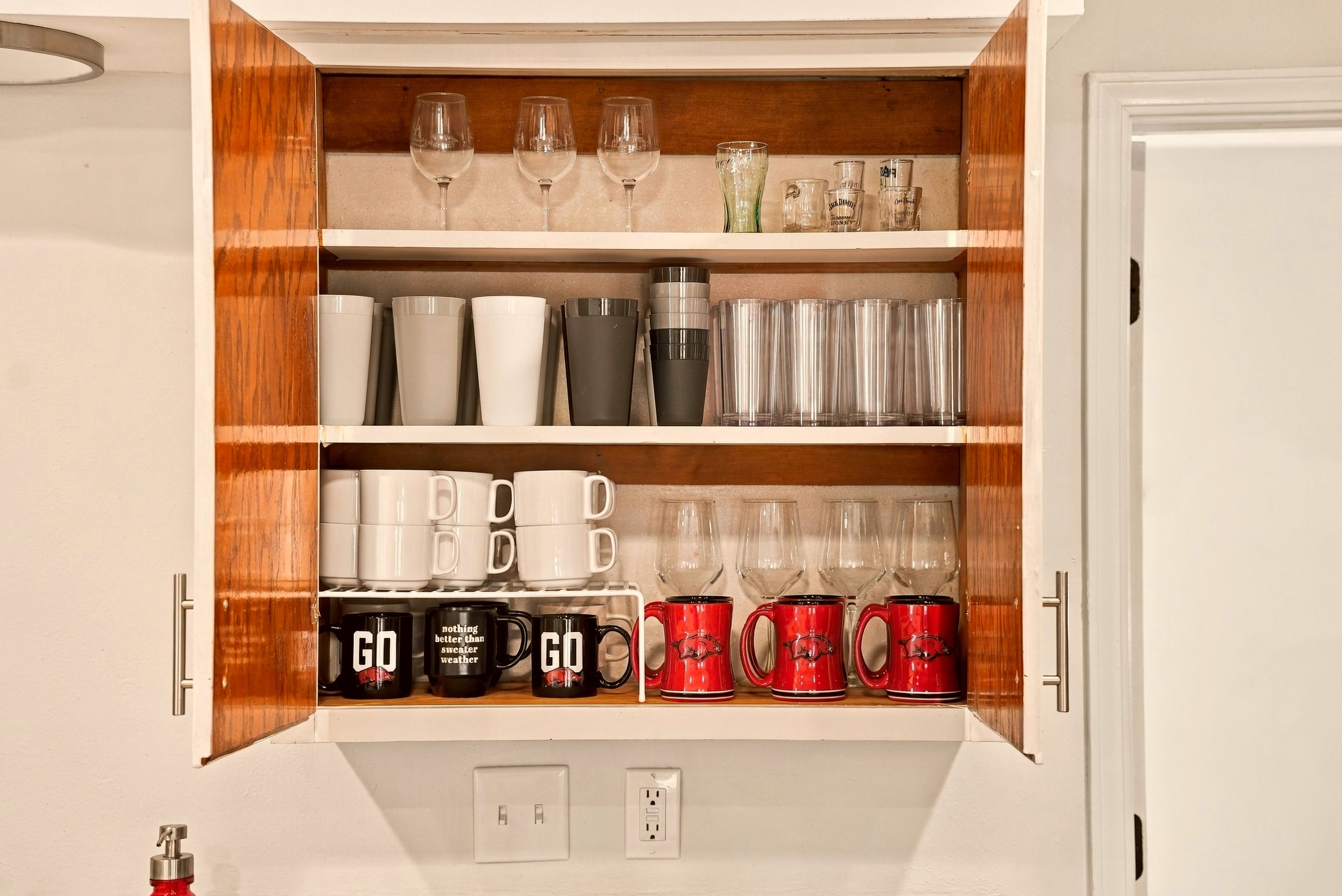 Un mueble con estantes que contiene diferentes vasos y tazas.