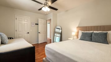 Guest bedroom with comfortable bed setup and wood-style flooring.