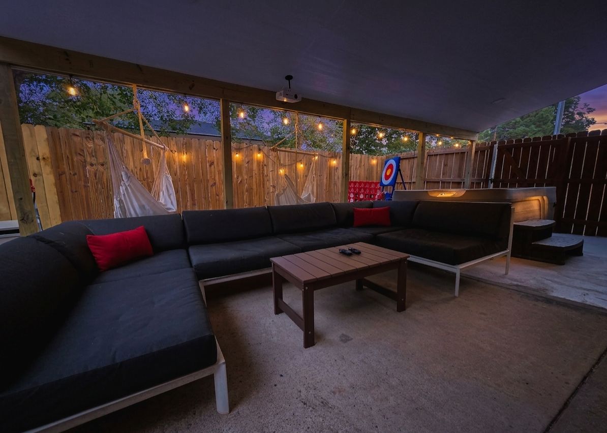 Un área de estar al aire libre con un sofá, una mesa de centro y un dardo.