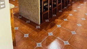 A kitchen with wooden cabinets, a granite countertop, and a central island with bar stools.
