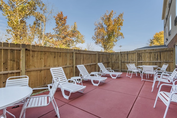 Relax in style on the patio with comfortable lounge chairs and a small table.