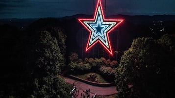 En stor, oplyst stjerneformet konstruktion i en park.