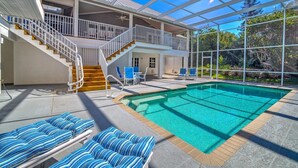 A two-story house with a swimming pool, outdoor seating, and a covered patio. - Spacious Single Family Home "Breaking Away" Steps from the Beach (Sanibel)
