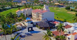 Un resort con diversi edifici, una piscina e un campo da golf.