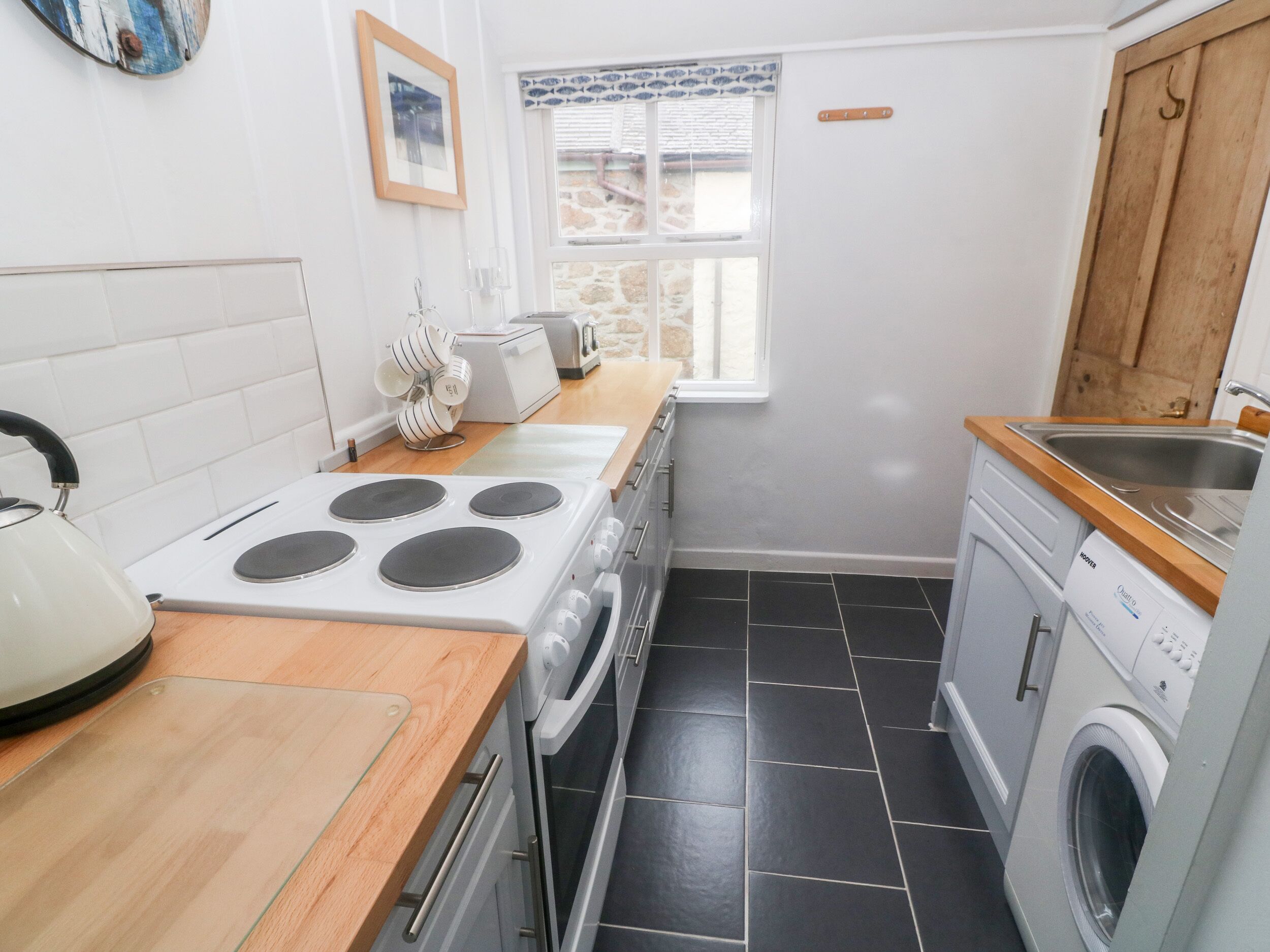 A compact kitchen with a stove, oven, and washing machine.