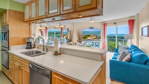 Una cucina moderna con mobili in legno, lavastoviglie, un lavello a due vasche e un'area pranzo con vista.