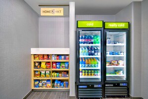 Un área de venta automática con refrigerios y dos dispensadores de bebidas, uno etiquetado 'frío' y otro 'muy frío'.