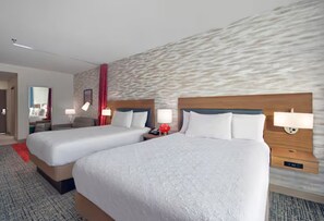 Een hotelkamer met twee bedden, een muur met een stenen patroon en een rood gordijn.