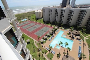 Ein Hotel mit Tennisplatz, Pool und Meerblick.
