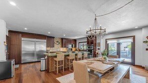 A modern kitchen with a central island, stainless steel appliances, and a chandelier. - Island pool home awaits in Islamorada's Port Antigua (Islamorada)