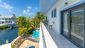 A balcony with a view of a swimming pool and a marina. - Island pool home awaits in Islamorada's Port Antigua (Islamorada)